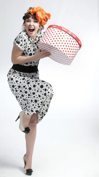 Happy girl holding gift box with red polka dots — Stock Photo, Image