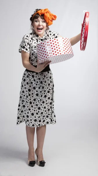 Happy girl opening gift box with red polka dots — Stock Photo, Image