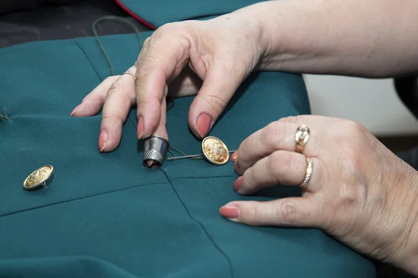 Woman hands sewing a button — Stock Photo, Image