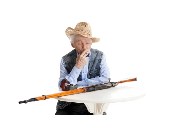 Man with a gun smokes a cigarette — Stock Photo, Image