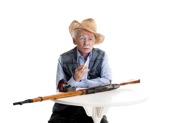 El hombre con un arma fuma un cigarrillo — Foto de Stock