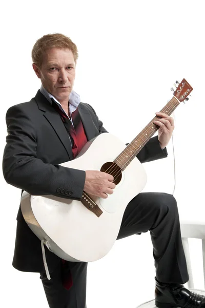 Человек в костюме играет на гитаре — стоковое фото