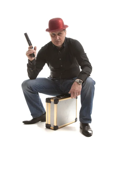 Man with a pistol sitting on the case — Stock Photo, Image