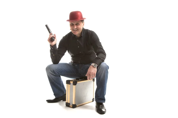 Un hombre con una pistola sentado en el maletín — Foto de Stock