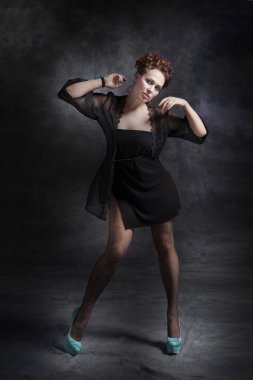 kadın siyah bir elbise ve topuklu ayakkabılarını