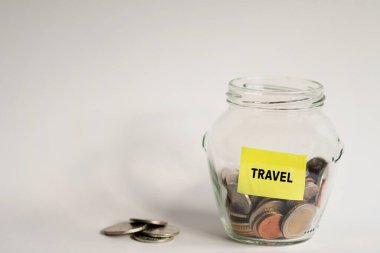 Stockholm, İsveç - 17 Ocak 2022: Tatil veya seyahat için para biriktirme kavramı. Hem cam kavanozda hem de kavanozun dışında bozuk paralar var.. 