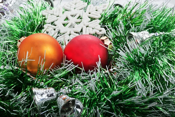 Два рождественских бала в зеленой гирлянде с колокольчиками и белым снежинкой — стоковое фото