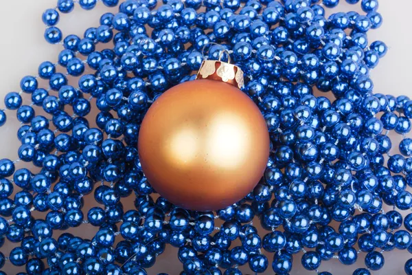 Orange Christmas ball and blue beads — Stock Photo, Image