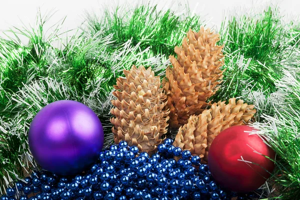 Christmas balls and cones with green garland and blue beads — Stock Photo, Image