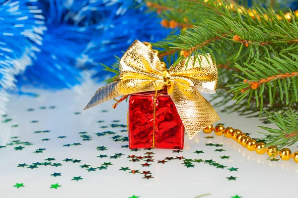 Presente de Natal vermelho com um arco sob a árvore de Natal — Fotografia de Stock