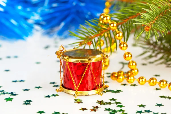 Красный барабан под деревом с золотыми бусами — стоковое фото