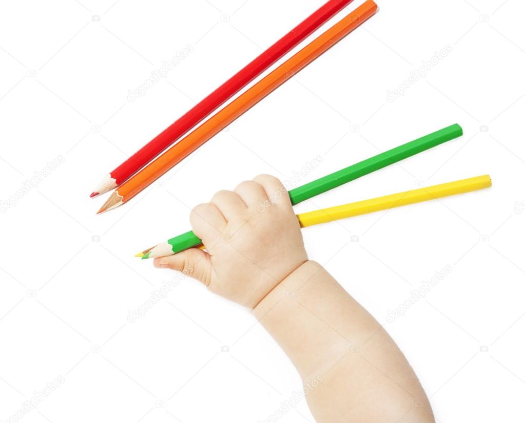 children's hand holds colour pencils