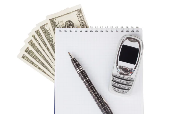 Dólares, bloc de notas, bolígrafo y teléfono móvil sobre un fondo blanco — Foto de Stock