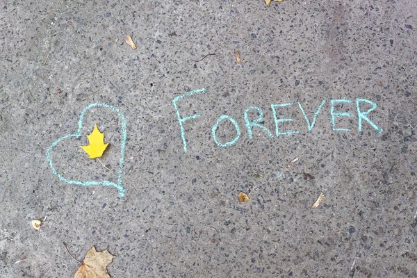 Srdce a nápis křídou"navždy" na beton — Stock fotografie