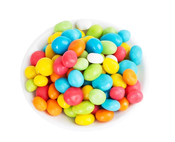 Gekleurde snoepjes in witte schotel — Stockfoto