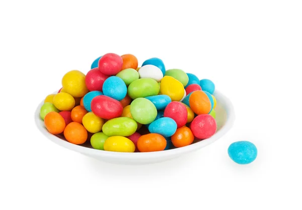 Caramelos de colores en platillo blanco — Foto de Stock