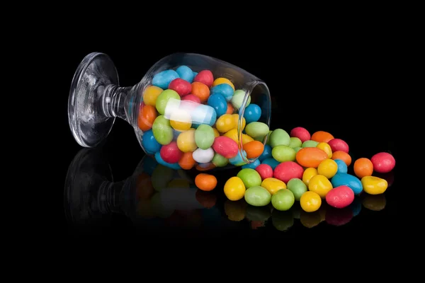 Kolorowe cukierki w odwrócony szklany — Zdjęcie stockowe