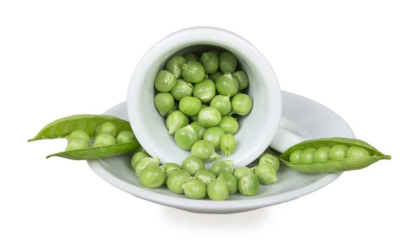 Fresh green peas in an inverted white cup — Stock Photo, Image