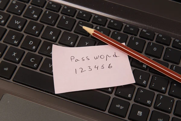 Haftnotiz mit Passwort und Bleistift auf schwarzem Laptop — Stockfoto