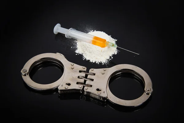 Sterty narkotyków kokainy z strzykawka i kajdanki — Zdjęcie stockowe