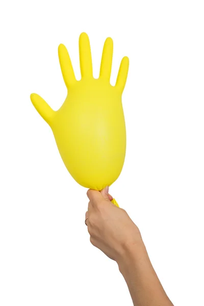 Female hand holding an inflated yellow glove — Stock Photo, Image