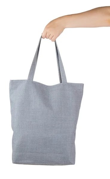 Mão feminina segurando um saco de compras têxtil cinza — Fotografia de Stock