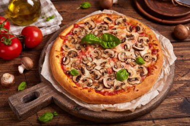 Mantarlı pizza. Amerikan usulü ev yapımı mantarlı pizza, mozzarella peyniri ve domates sosu. Taze yemlenmiş ve fesleğen yapraklarıyla servis edilmiş..