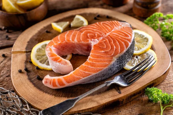 Een Verse Zalmsteak Een Rustiek Houten Tafelblad Met Citroen Peperkorrel — Stockfoto