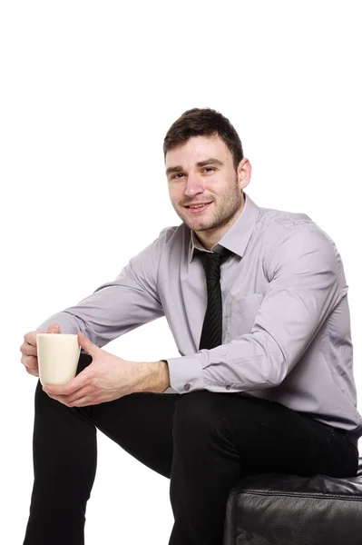 Homem de negócios sentado segurando uma xícara de café — Fotografia de Stock