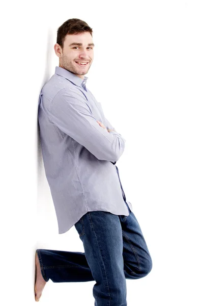 Handsome man leaning against a white wall — Stock Photo, Image