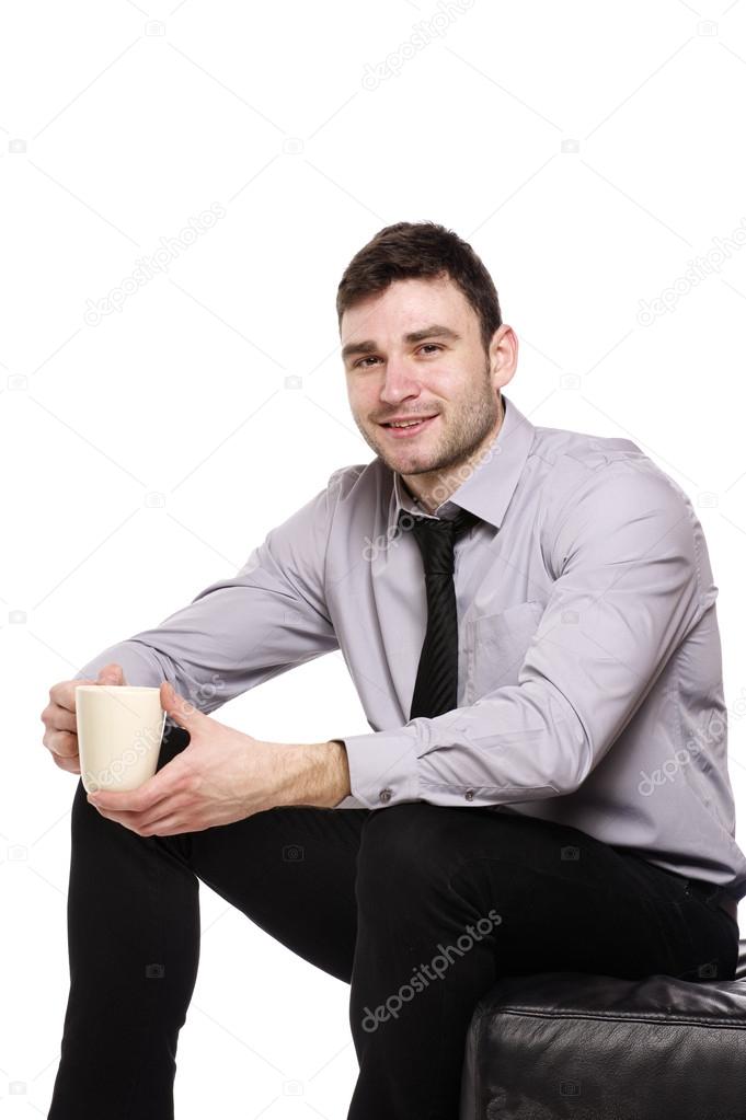 Business man sat holding a cup of coffee