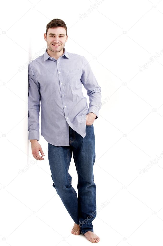 Handsome man leaning against a white wall