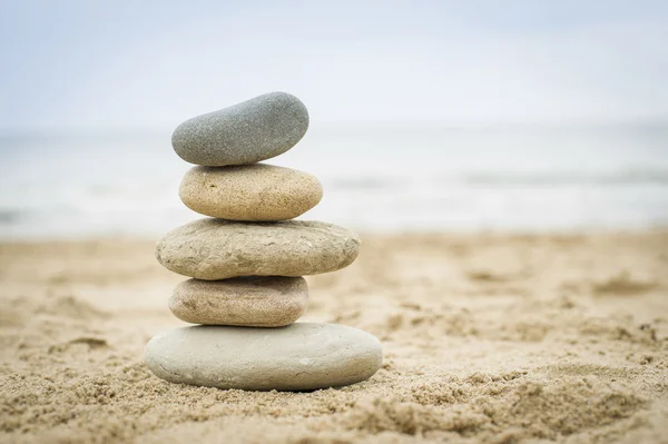 bir kum plajı üzerinde yığılı taşlar