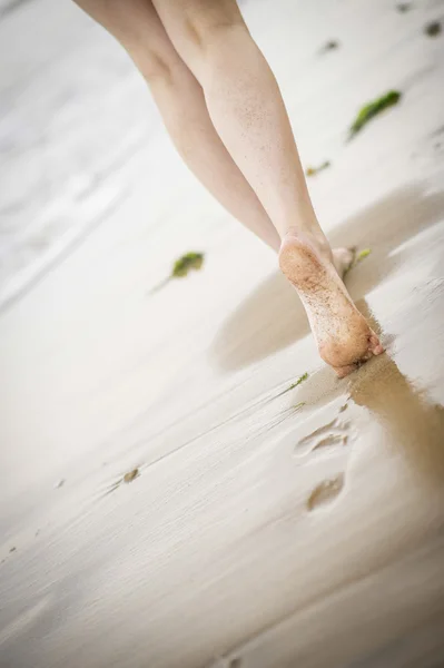 Woman's legs walking along the beach — Stock Photo, Image