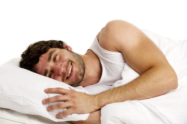 Homem deitado na cama branca sorrindo — Fotografia de Stock