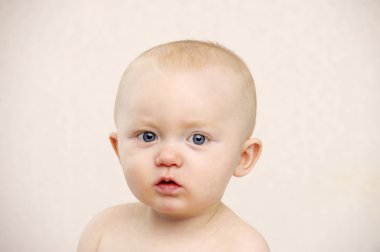 Bebek şeftali bir arka plan üzerinde kameraya bakıyor