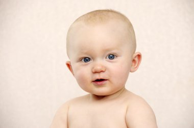 Bebek şeftali bir arka plan üzerinde kameraya bakıyor