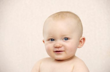 Bebek şeftali bir arka plan üzerinde kameraya bakıyor