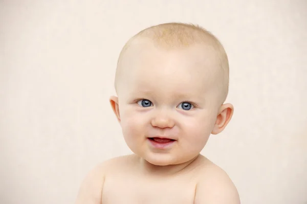 Baby kijken naar de camera op een perzik achtergrond — Stockfoto