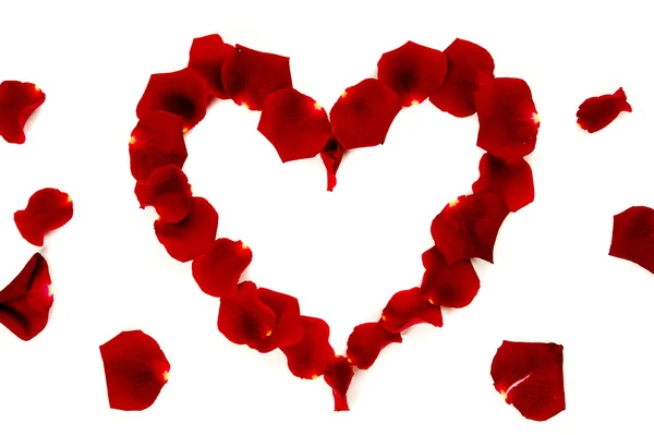 红色的玫瑰花瓣放在心的形状 — 图库照片