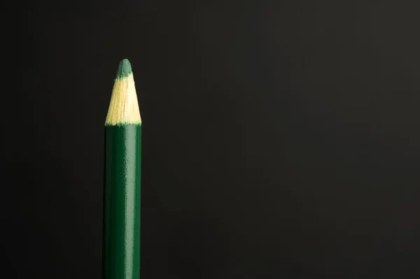 Green pencil crayon on a black background — Stock Photo, Image