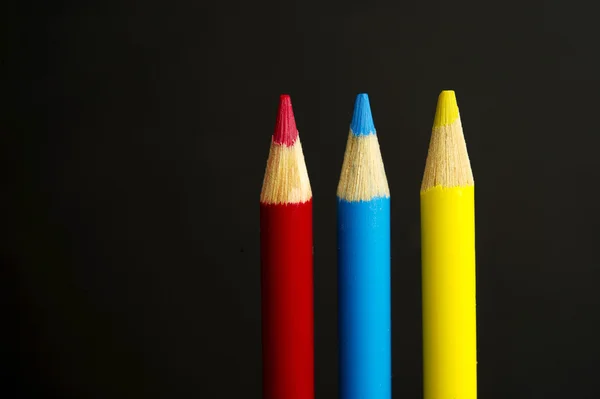 Primary coloured pencil crayons on a black background — Stock Photo, Image