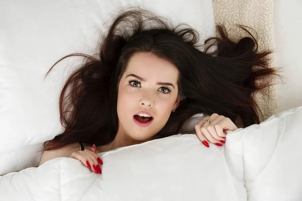 Mulher deitada na cama olhando para cima — Fotografia de Stock