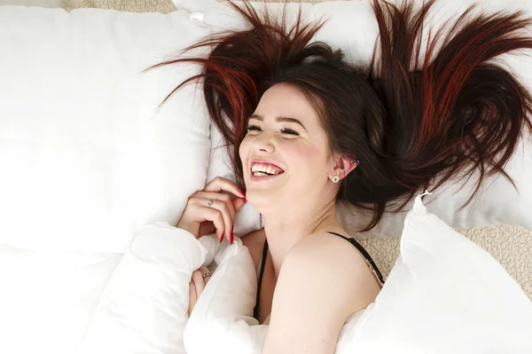 Woman laid in bed laughing — Stock Photo, Image