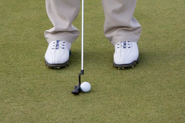 Golfschläger und Ball auf Abschlagrasen, Golfer bereitet sich auf Putt vor — Stockfoto
