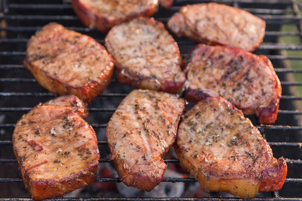 Dick gewürzten Schweinekoteletts Kochen auf dem Grill Stockbild