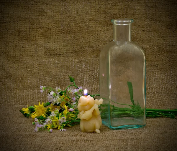 Stillleben mit leerer Flasche, Kerze und Blumen — Stockfoto