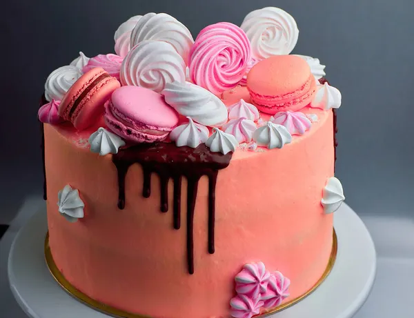 Lekkere roze taart versierd met macarons en chocolade — Stockfoto