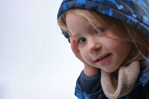 Adorable fille préscolaire posant avec la main sur sa joue capuche isolée sur la tête — Photo