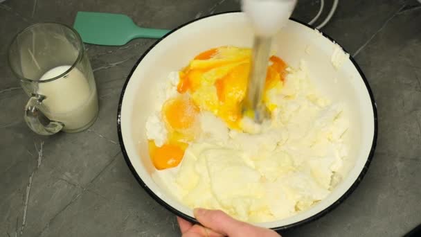 Blanda ost, ägg, socker, mjölk med dränkbar mixer för att förbereda ostkaka — Stockvideo
